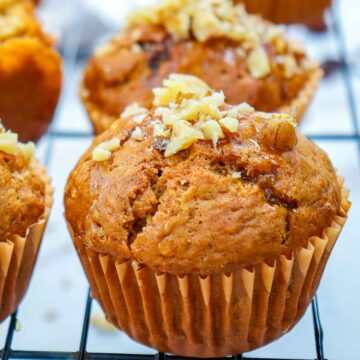 Close up of carrot cake muffins on a wire rack.