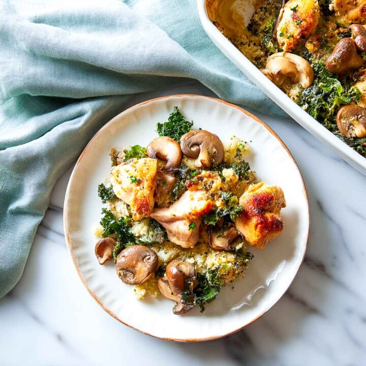 Chicken mushroom casserole served on a white plate with the baked dish in the background.