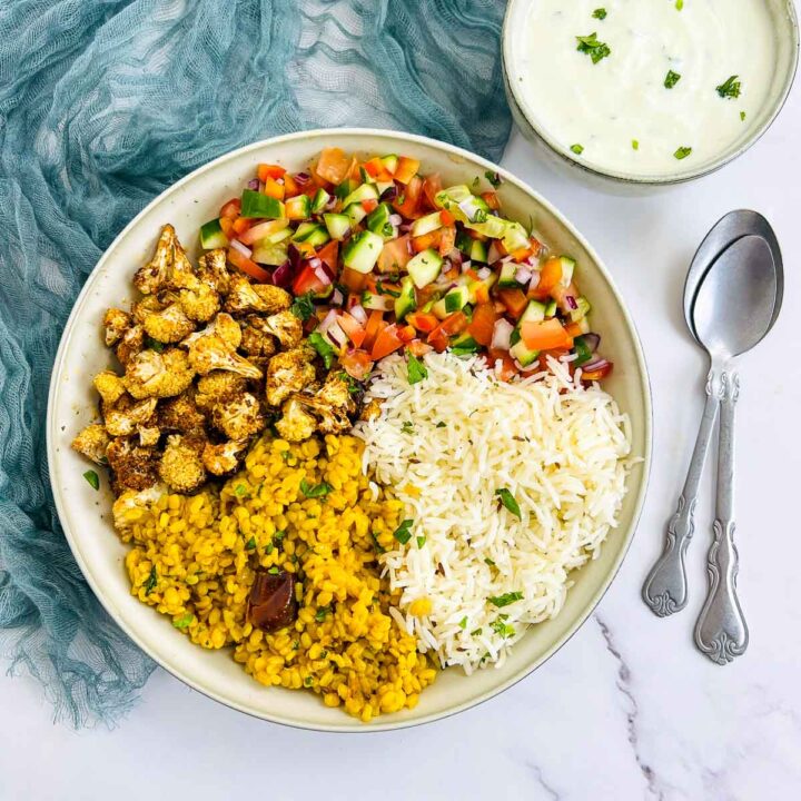Indian Buddha bowl with cauliflower, lentils, salad, and yogurt.