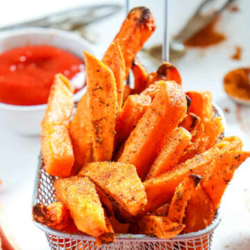 Air fryer sweet potato fries in a small basket.