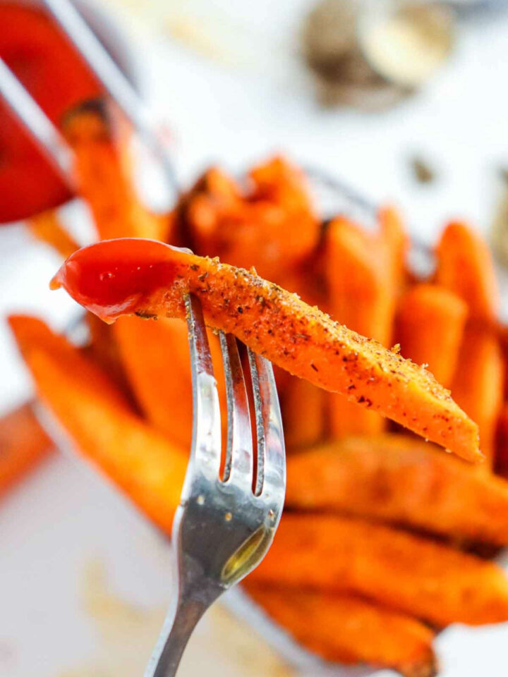 Close up of a single air fryer sweet potato fry on a fork.