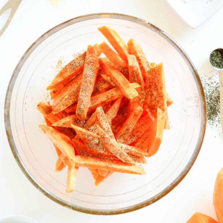 Cut sweet potato stickes seasoned in a bowl.