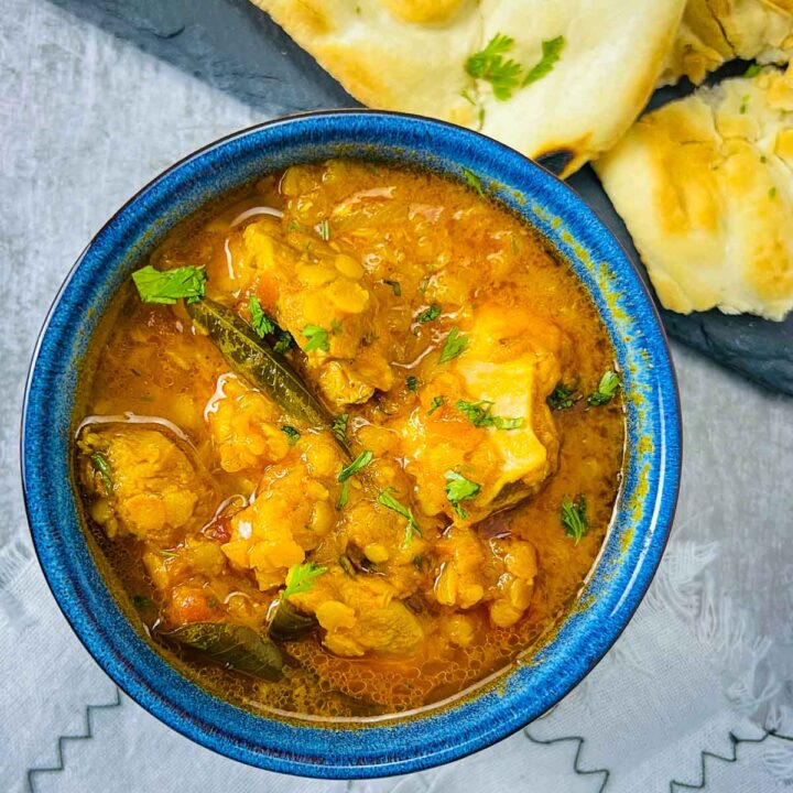 A bowl of chicken and red lentil curry.