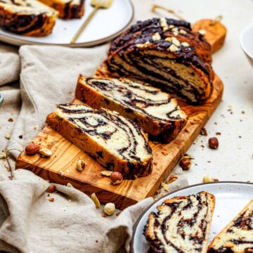 Chocolate hazelnut babka sliced and placed on a wooden board.