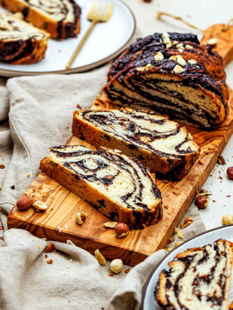 Top view of sliced chocolate hazelnut babka on a wooden board.