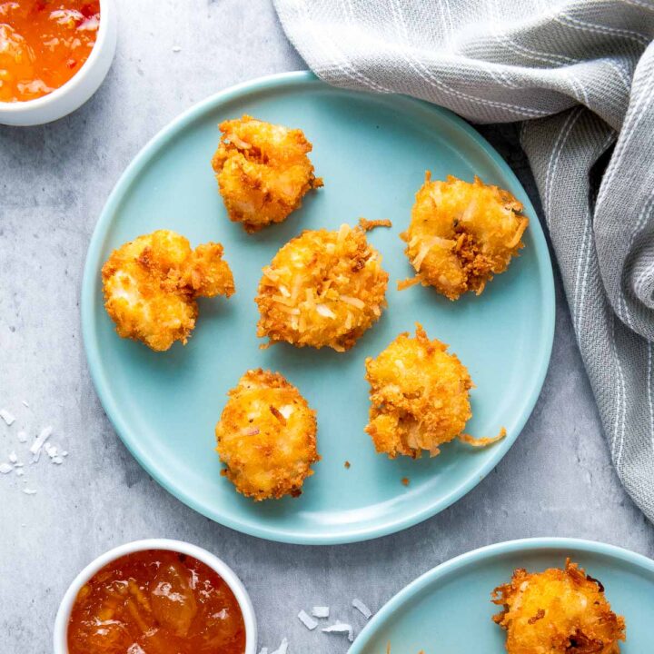 A plate of coconut shrimp served with dipping sauce.