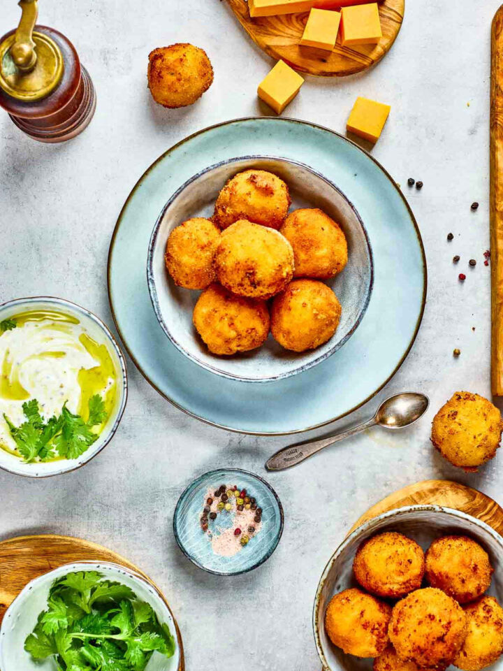 Top view of mac and cheese bites in a blue bowl.