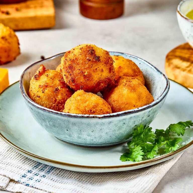 Mac and cheese bites served in a blue bowl.