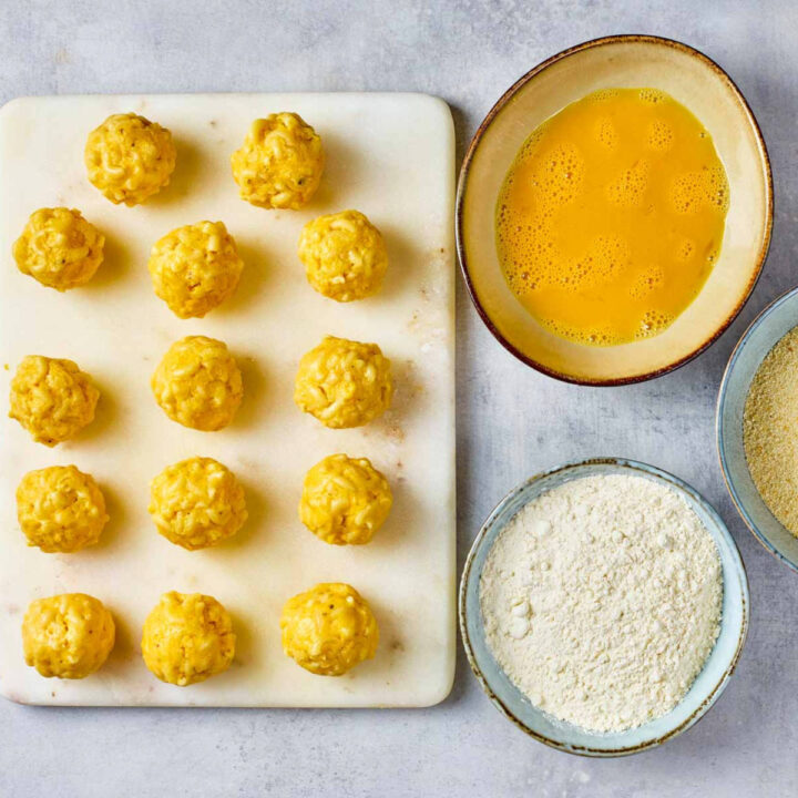 Small balls of mac and cheese bites ready to be breaded.