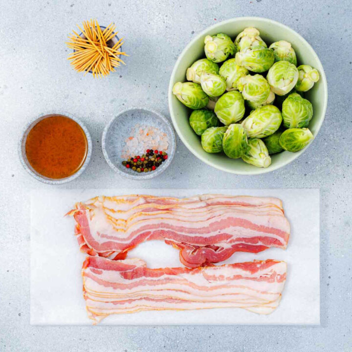 Ingredients to make bacon-wrapped Brussels placed on a kitchen counter.