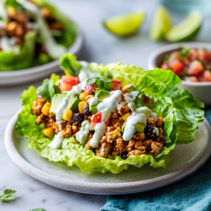Close-up of a single Tex-Mex lettuce cup with ground chicken and crema drizzle.