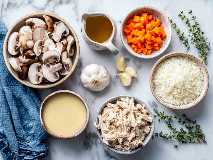 Top-down view of chopped vegetables, turkey, broth, and rice ingredients.