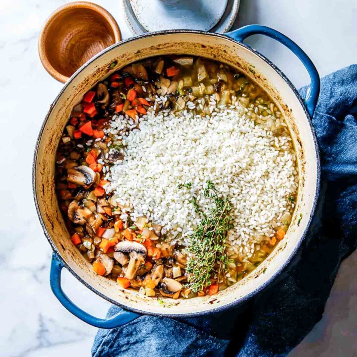 Uncooked rice added to sautéed vegetables in Dutch oven before simmering.