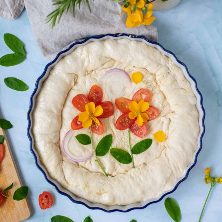 Punch down the dough and transfer it to an oiled baking sheet. Stretch the dough to cover the pan evenly. Cover and let rise again for 20 minutes.