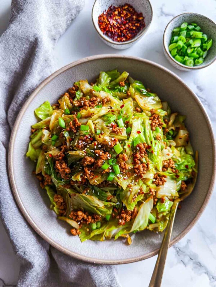 Spicy ground turkey cooked with cabbage and vegetables served in a shallow bowl.