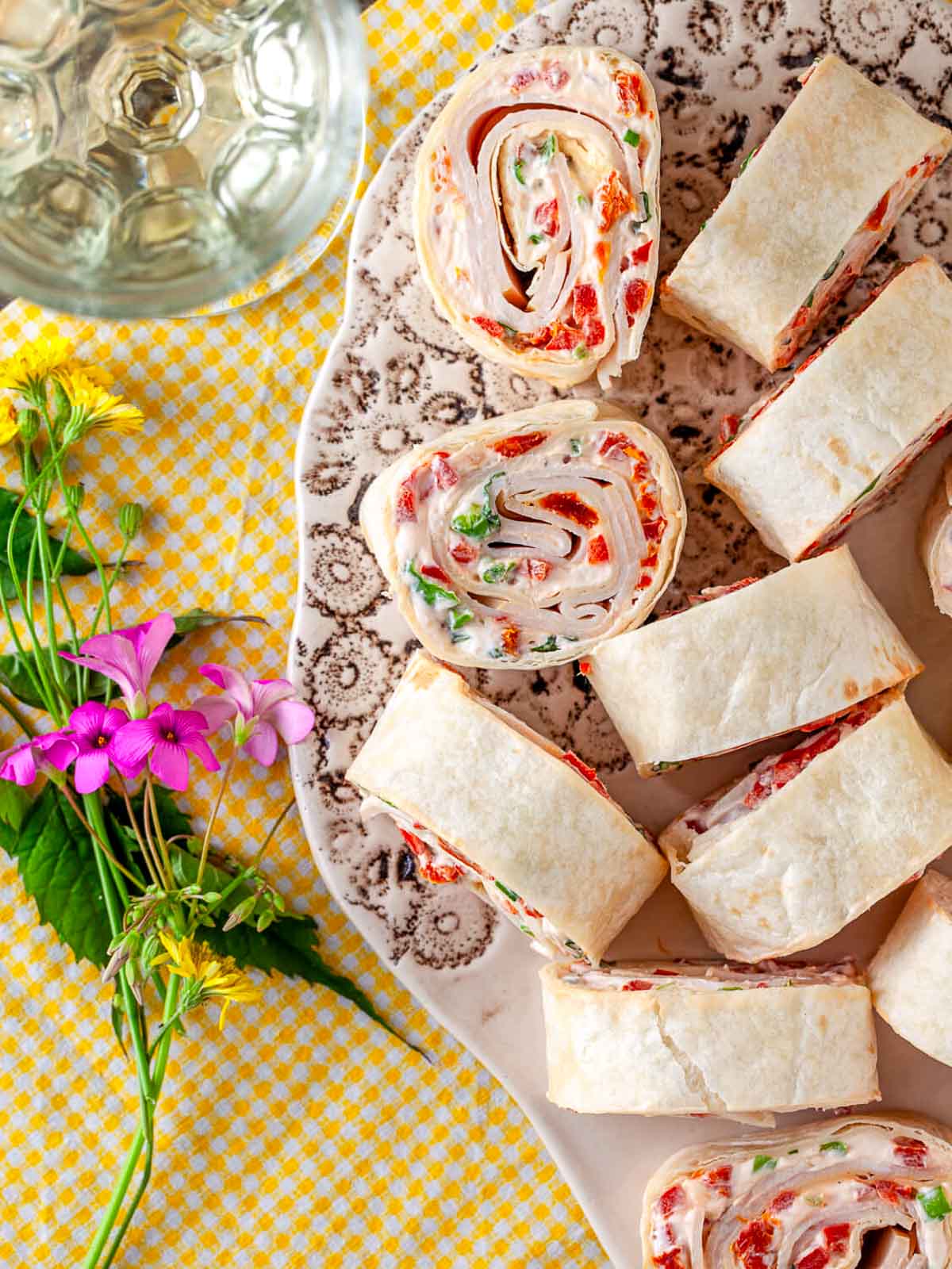 Sliced turkey and sun-dried tomato pinwheels on a serving plate.