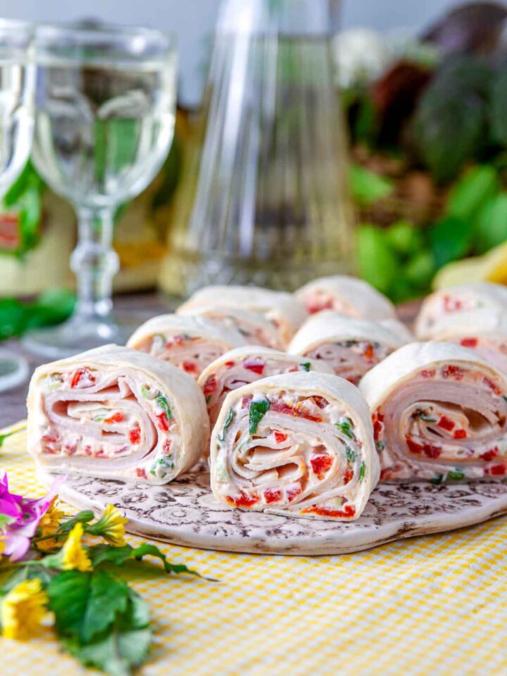 Side view of turkey and sun-dried tomato pinwheel sandwich on a serving plate.