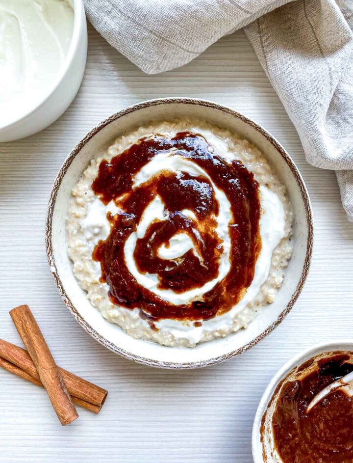 Bowl of creamy oatmeal swirled with cinnamon sauce and yogurt.