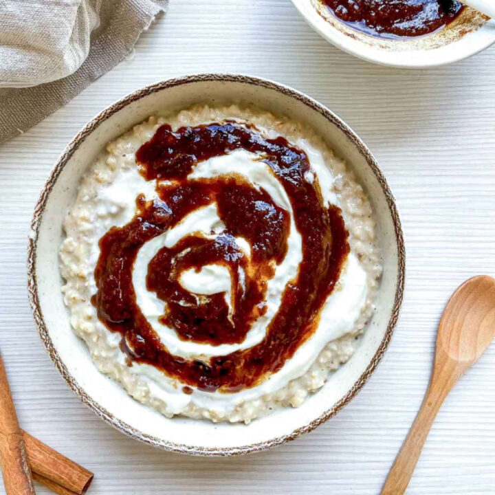 Cinnamon roll oatmeal served in a bowl, topped with a rich cinnamon swirl and creamy glaze.