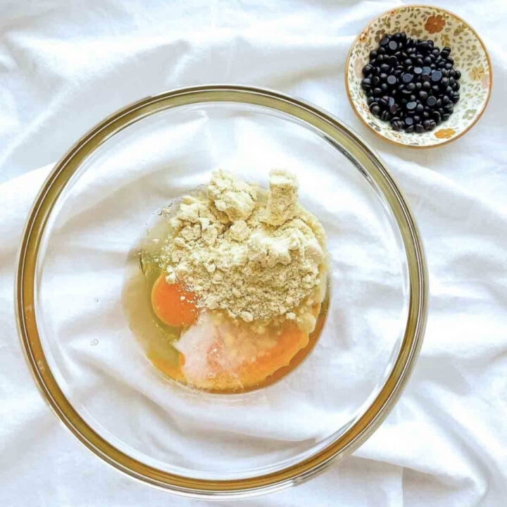 Coconut flour cookie ingredients in a glass bowl, including egg, coconut flour, and sweetener before mixing