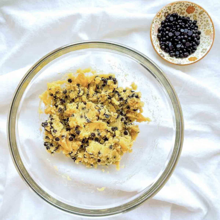 Coconut flour chocolate chip cookie dough mixed in a glass bowl with chocolate chips evenly folded throughout