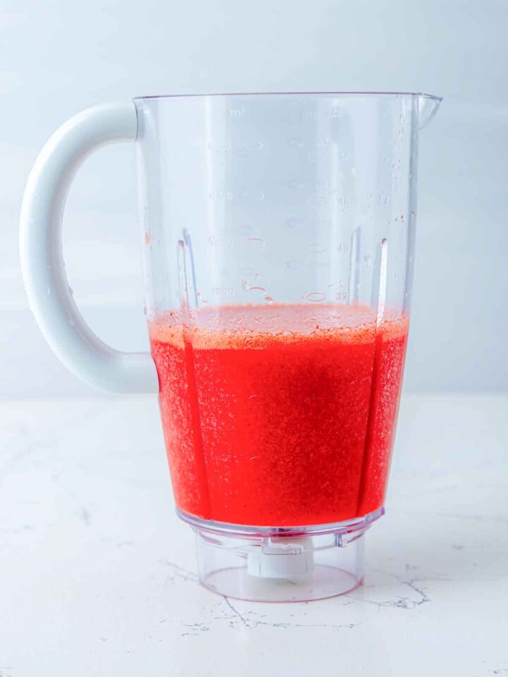 Blender pitcher with strawberry mixture.