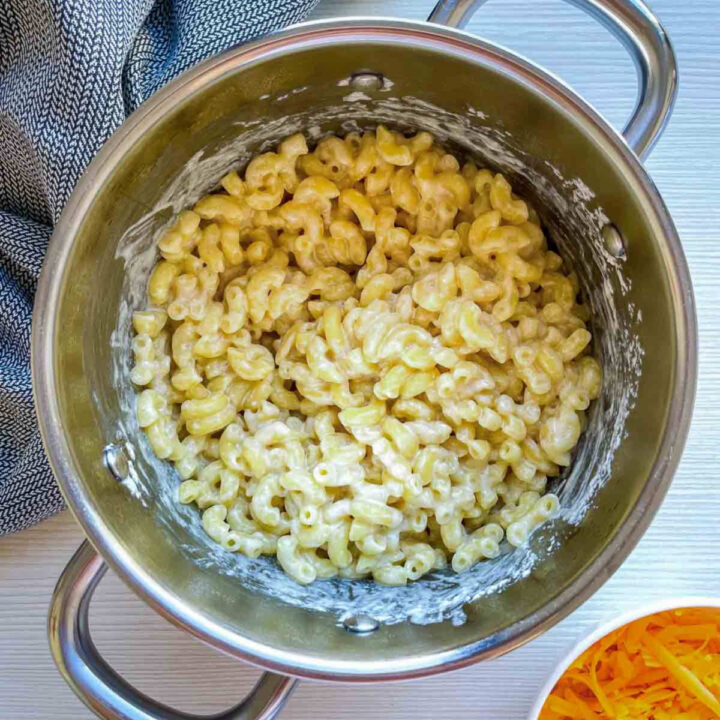 Cooked macaroni coated in creamy cheese sauce in a pot.