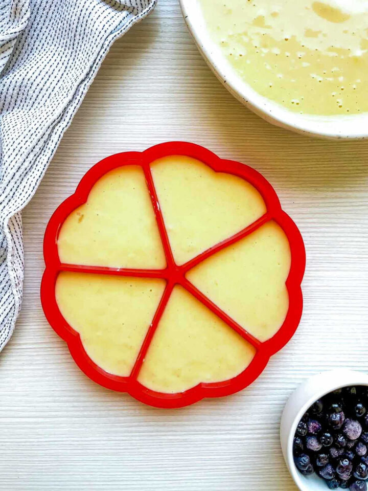 Waffle batter poured into a flower-shaped silicone mold, ready to cook.