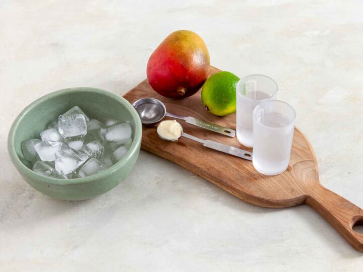 Mango daiquiri ingredients: mango, lime, ice, coconut cream, and rum.