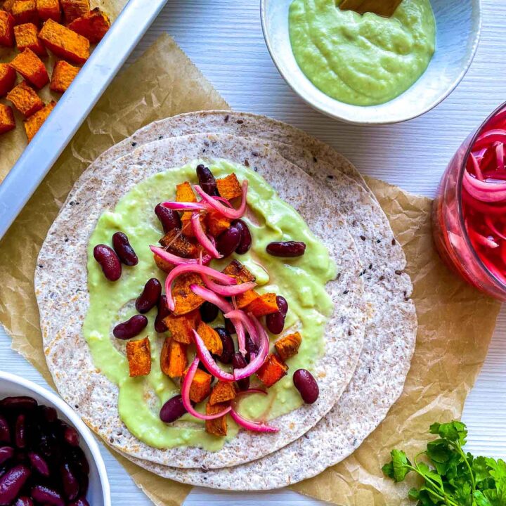 Sweet potato and red bean taco with creamy avocado sauce and pickled onions.