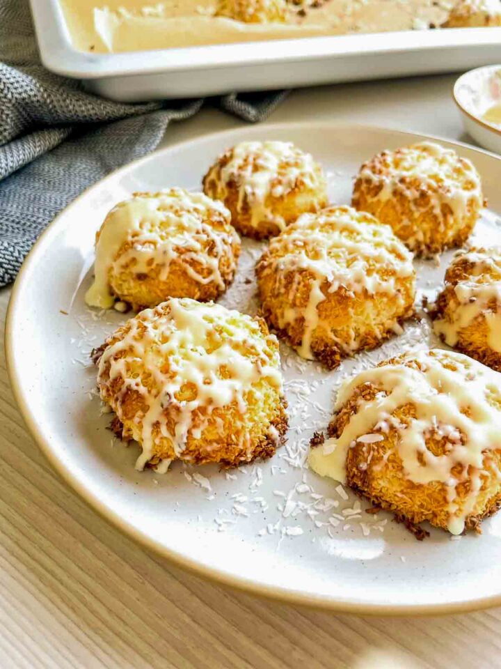 Tequila white chocolate coconut macaroons drizzled with white chocolate, arranged on a white plate