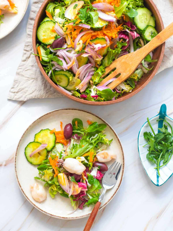 A plate of Garden Salad with Calamari with the serving bowl in the background.
