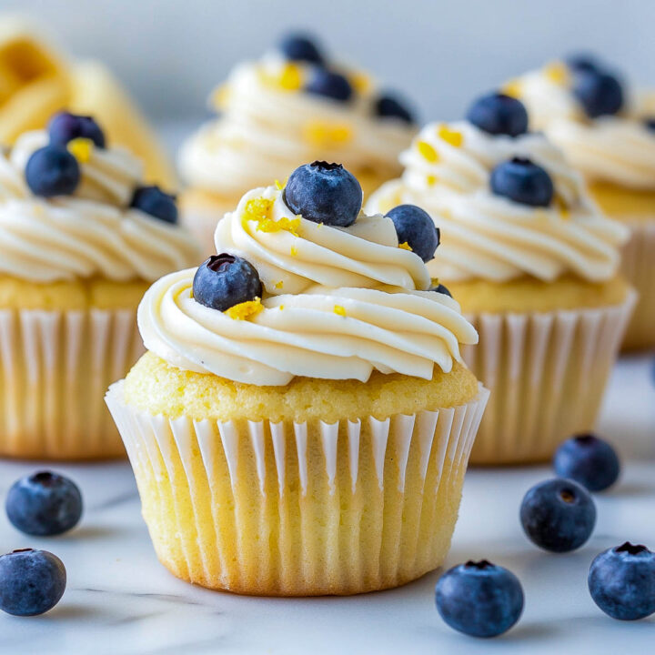 Side view of lemon blueberry cupcakes topped with fresh blueberries.