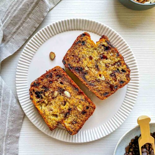 Moist banana bread studded with chocolate chips and crunchy almonds, sliced to reveal a tender, flavorful crumb.