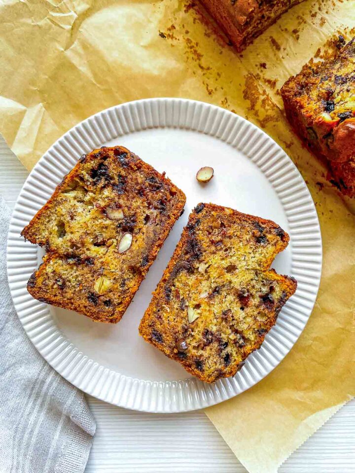 Two slices of banana bread studded with chocolate chips and crunchy almonds.