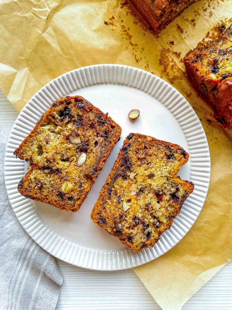 Two slices of banana bread studded with chocolate chips and crunchy almonds.