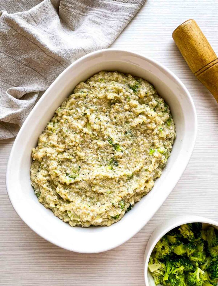 Creamy broccoli gratin in baking dish before adding the breadcrumb topping.