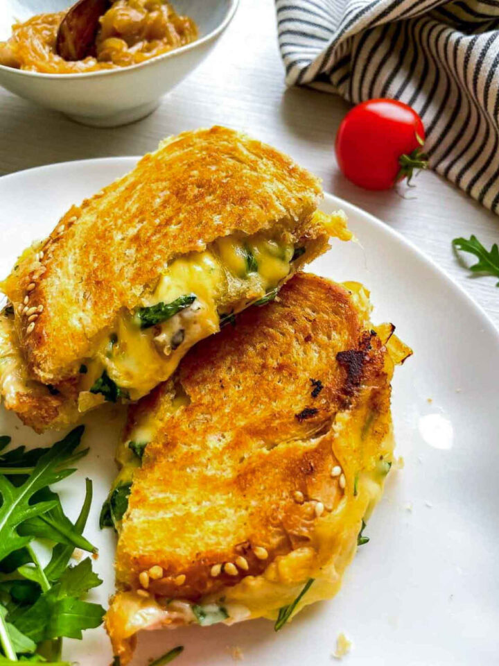 Grilled cheese sandwich halves with melted cheese on plate