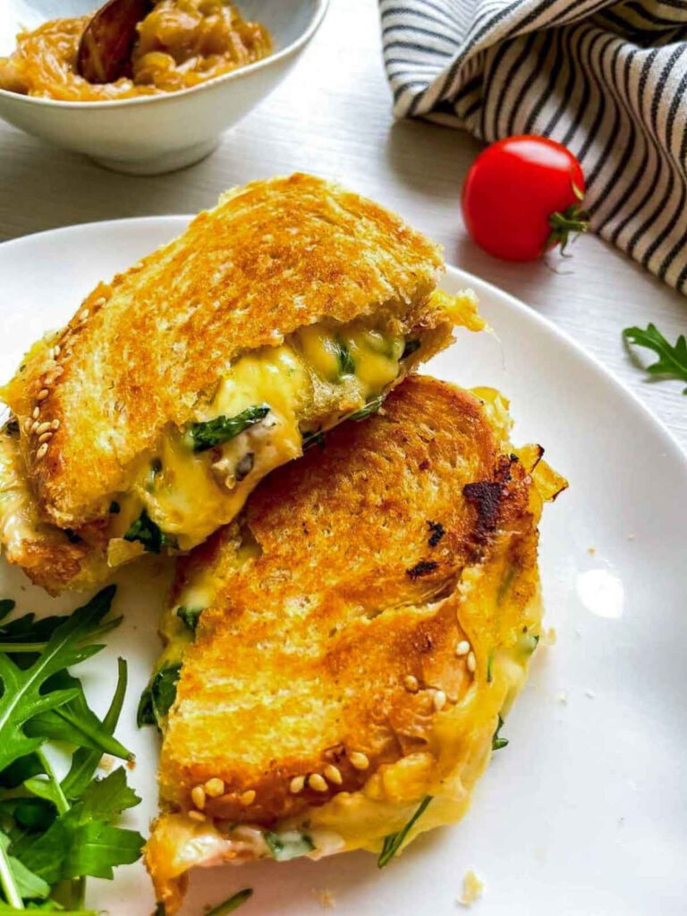 Grilled cheese sandwich halves with melted cheese on plate