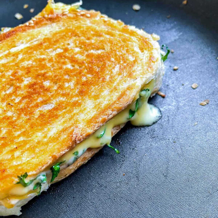 Close-up of melted cheese oozing from grilled sandwich