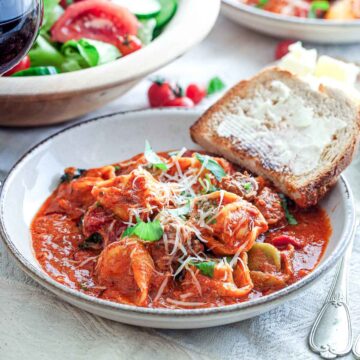 Cheesy tortellini in tomato sauce with sausage, basil, and buttered toast