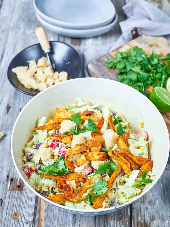 A vibrant, creamy salad loaded with beans, corn, and fresh veggies, finished with crunchy strips, herbs, and cheese for a perfect mix of flavor and texture.