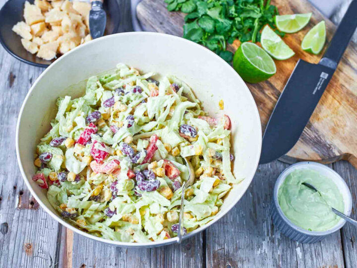 The salad is tossed together, evenly coated in a creamy dressing with beans, corn, and fresh vegetables.