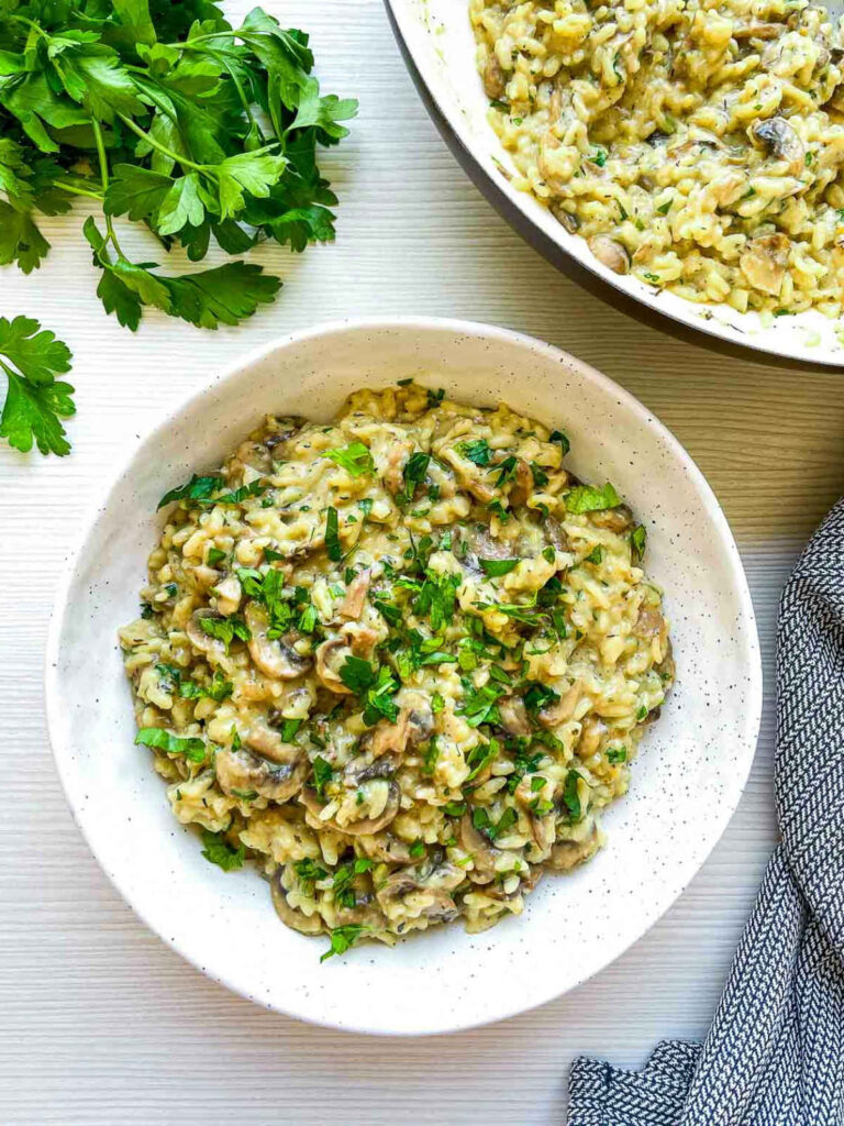 Creamy mushroom herb rice garnished with fresh herbs.