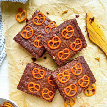 Slices of salted pretzel brownies placed on a parchment paper.