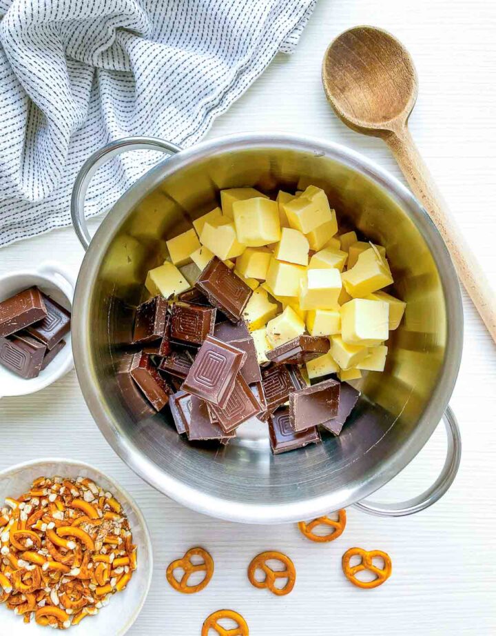 Chopped chocolate and butter in a saucepan with pretzels