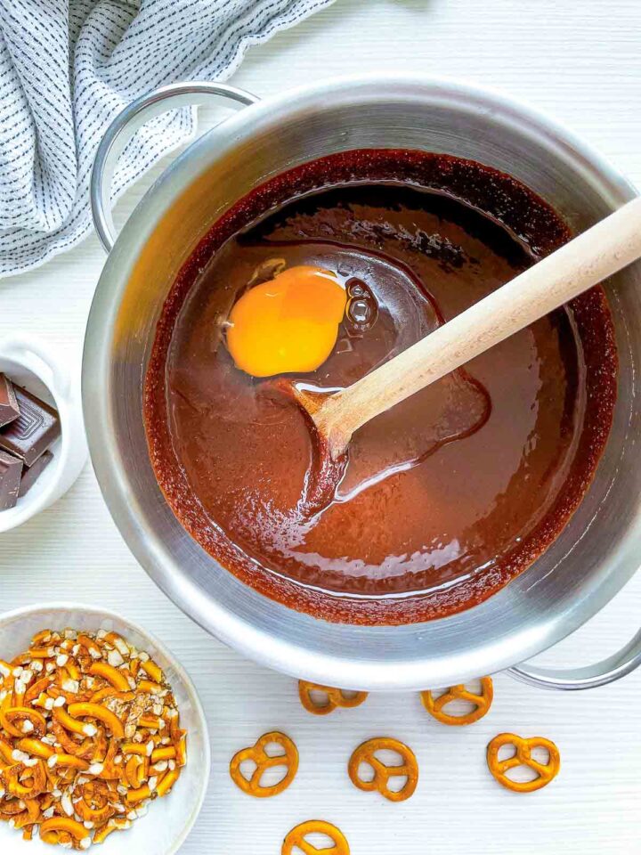 Egg added to melted chocolate mixture in saucepan