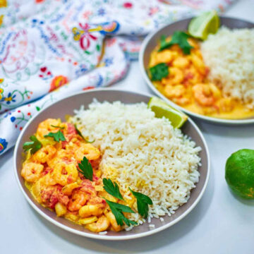 A rich and creamy prawn tikka masala paired with fluffy rice, garnished with fresh herbs and lime for a bright, comforting finish.