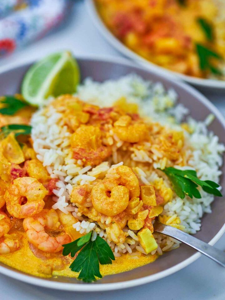 Shrimp tikka masala mixed with basmati rice and served in a grey bowl.