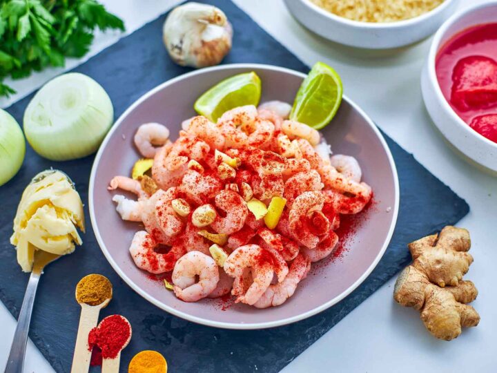 Shrimp are seasoned with spices, garlic, and ginger, building a bold and aromatic flavor base.